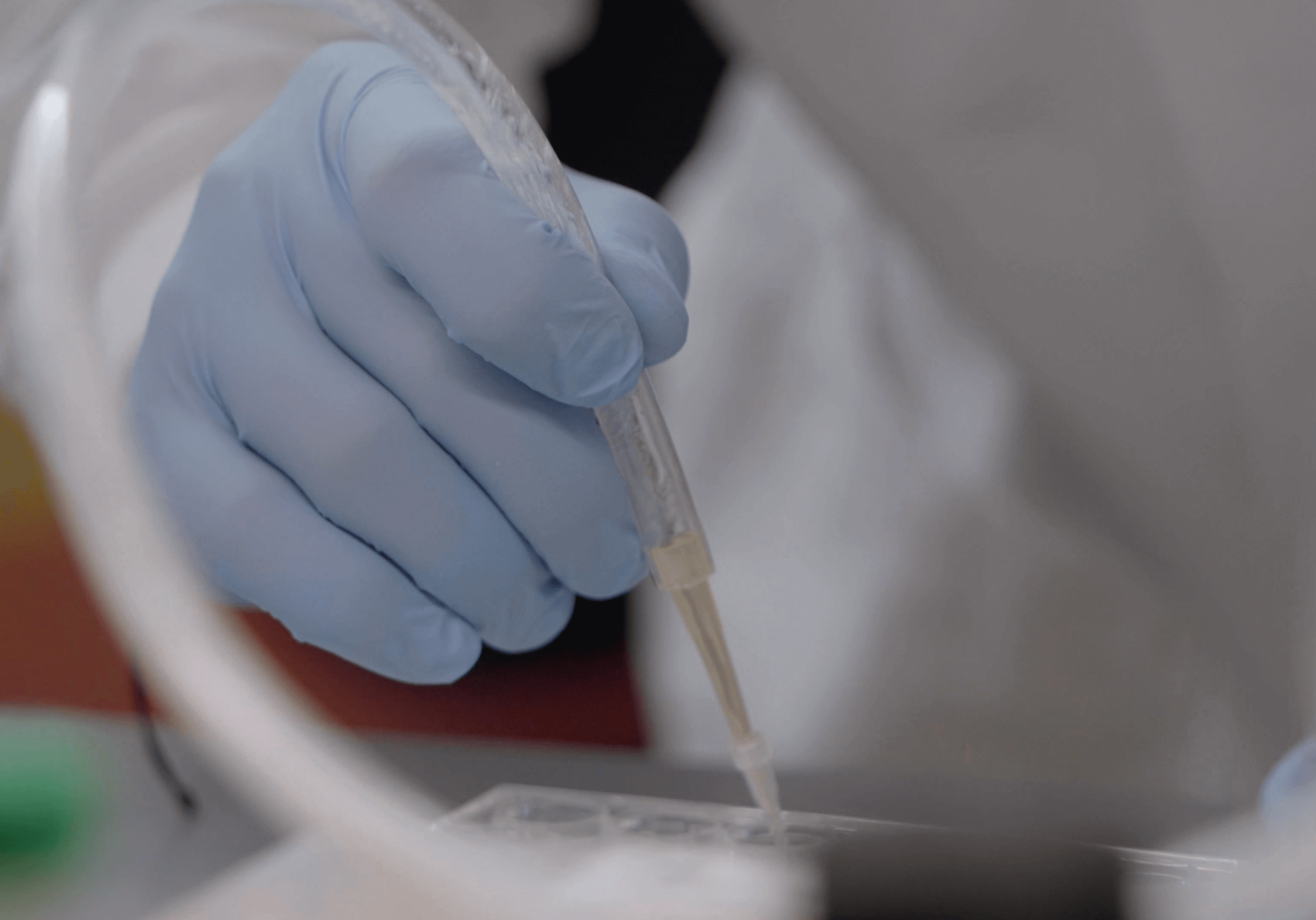 Lab worker using a dropper.